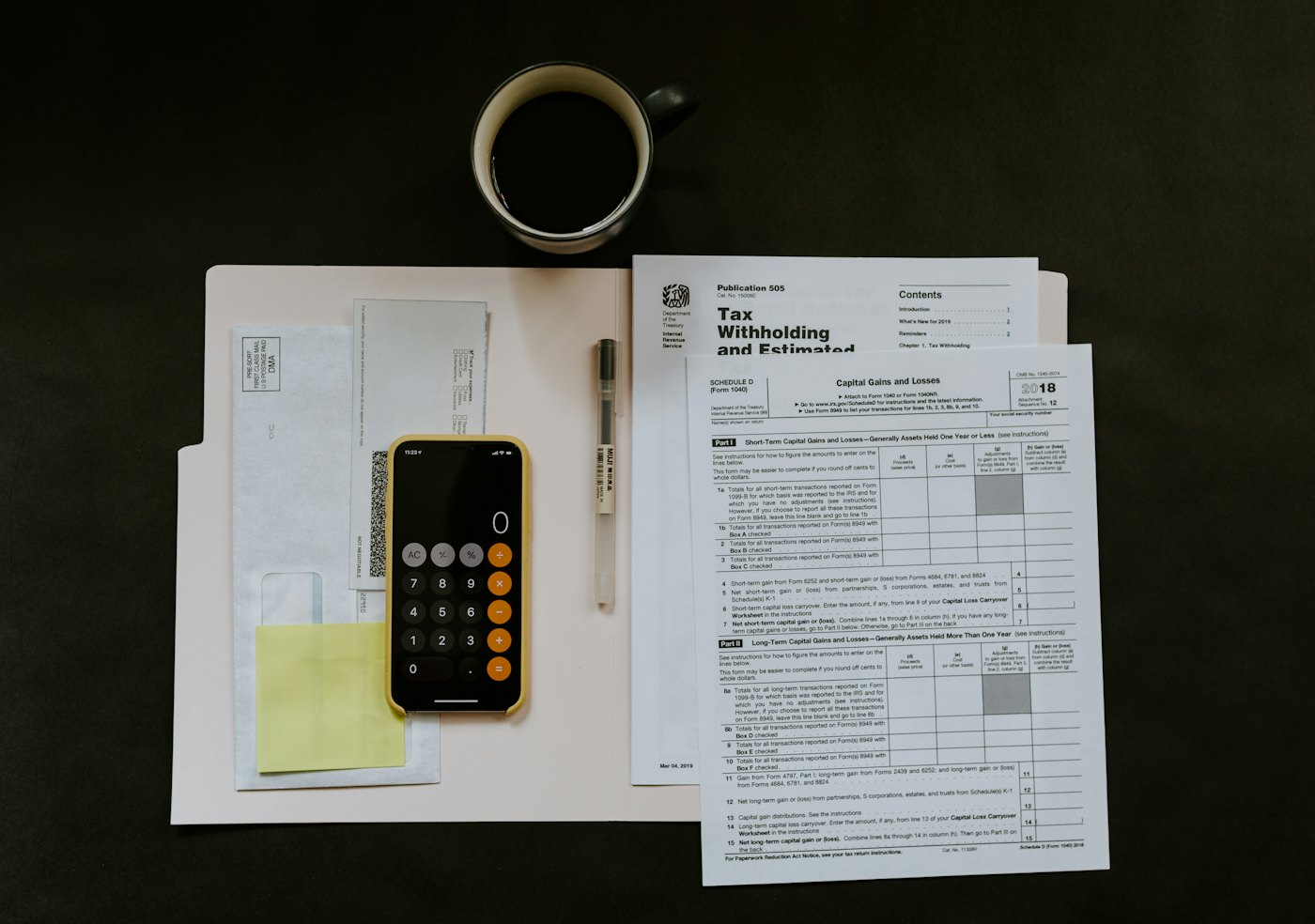 Documentos de adeudos y calculadora revisados sobre una mesa